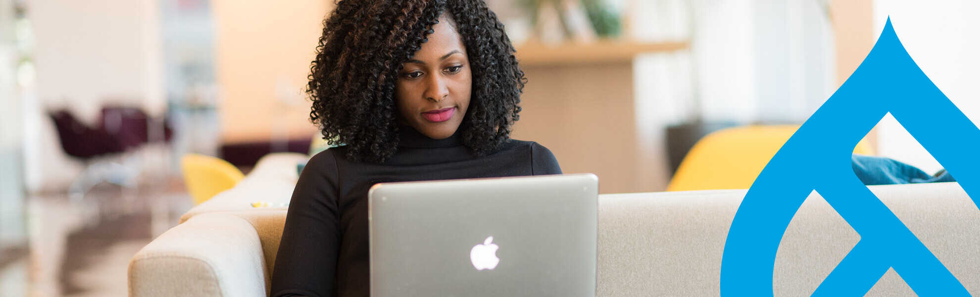 woman sitting at laptop with drupal logo